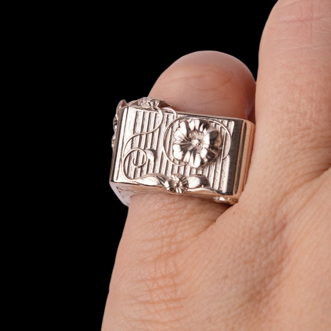 unusual hibiscus ring on a finger